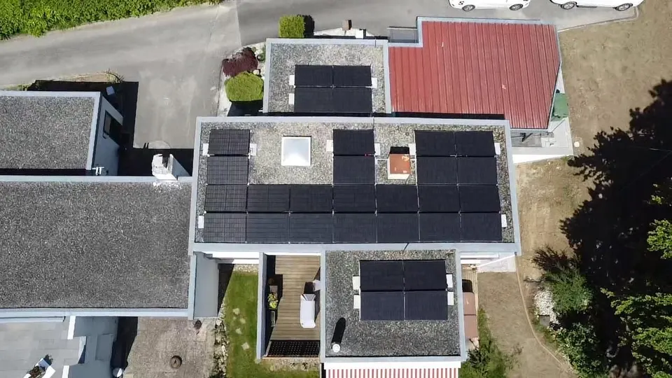 Vue aérienne : modules solaires noirs sur le toit plat d’une maison individuelle à Villars-sur-Glâne (environs : jardin)