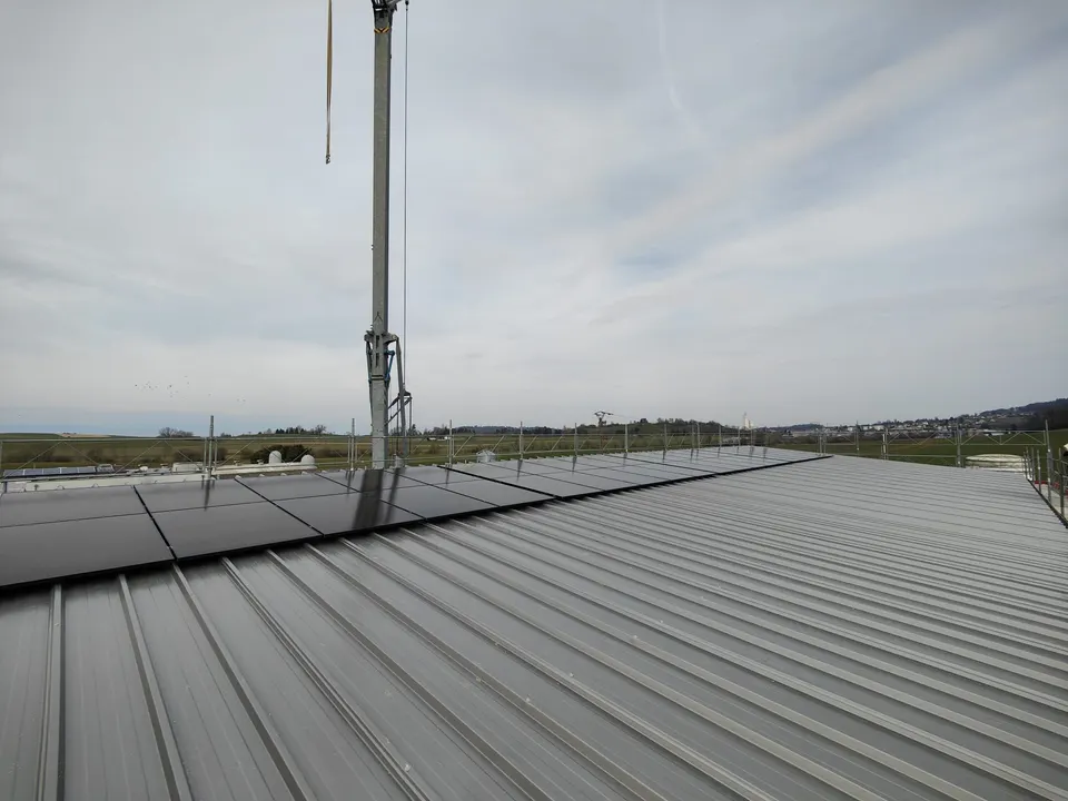 Schwarze Solarmodule auf dem Blechdach einer Halle in Cournillens (Umgebung: Wiesen)