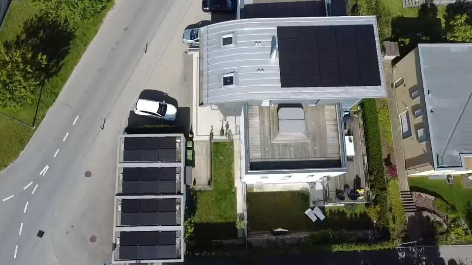 Vue aérienne : modules solaires noirs sur le toit plat d’une maison individuelle à Villars-sur-Glâne (environs : maisons voisines)