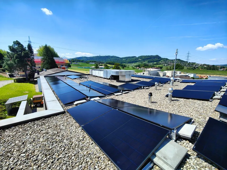 Modules solaires noirs sur le toit plat d’une maison individuelle à Bossonnens (environs : prés)