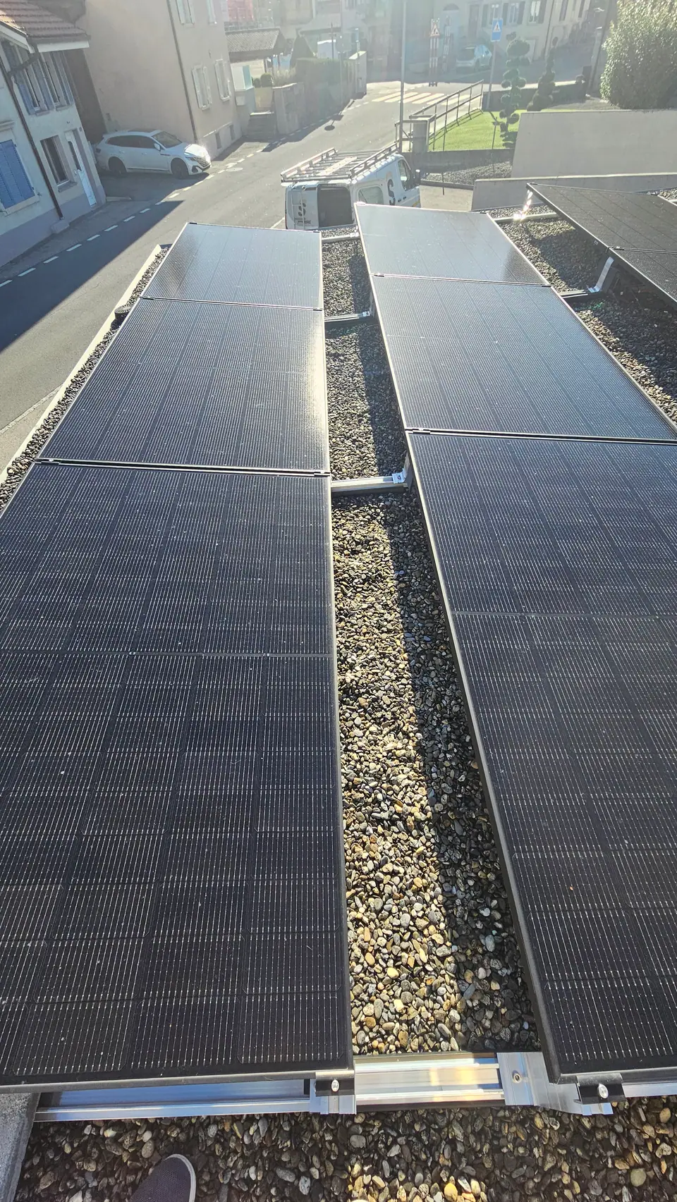 Modules solaires noirs surélevés sur le toit plat gravillonné de l’immeuble à Châtel-St-Denis
