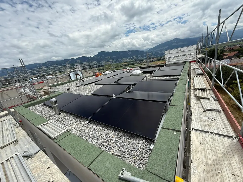 Schwarze Solarmodule auf dem Flachdach eines neuen Einfamilienhauses in Marsens (Umgebung: Berge)