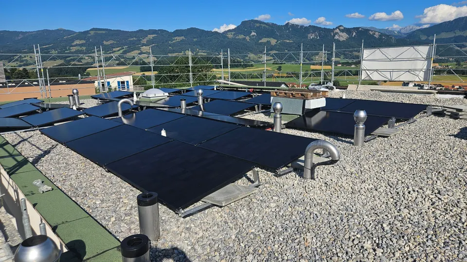 Schwarze Solarmodule auf dem Flachdach eines neuen Einfamilienhauses in Marsens (Umgebung: Berge)