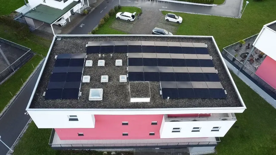 Luftbild: schwarze Solarmodule auf dem Flachdach einer Wohnanlage im Stockwerkeigentum in Bulle (Umgebung: Nachbarhäuser) – weitere Ansicht