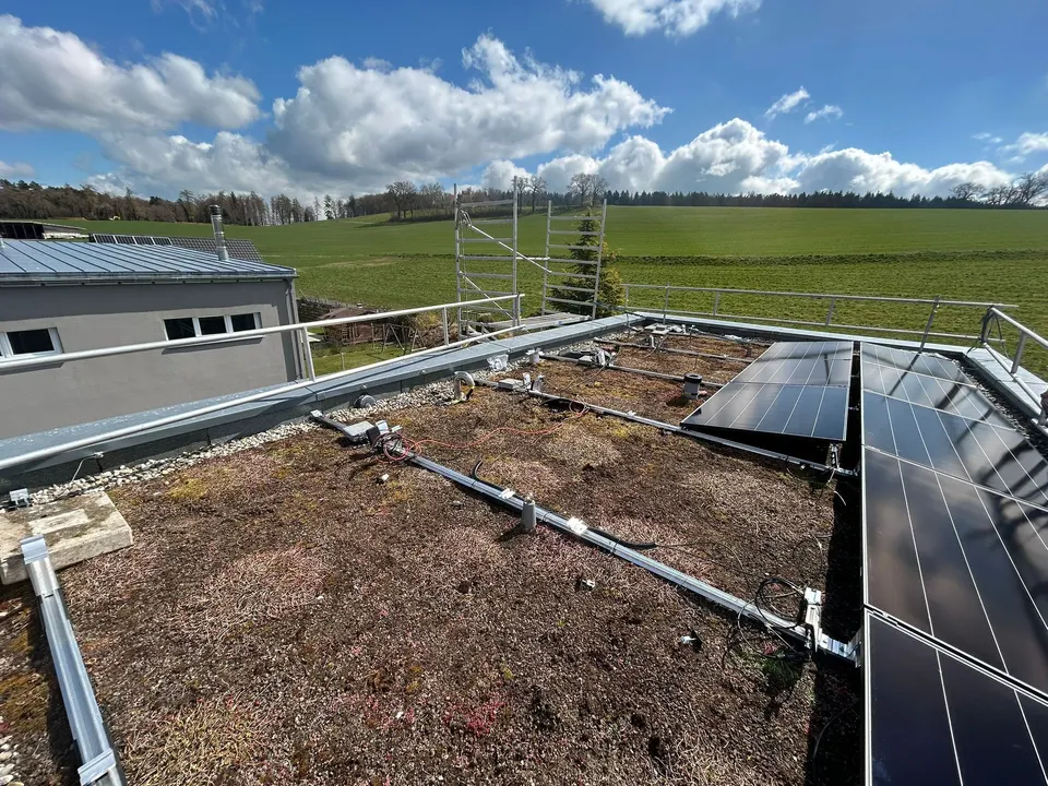 Modules solaires noirs sur le toit plat végétalisé d’une maison individuelle à Formengueires (environs : prés)