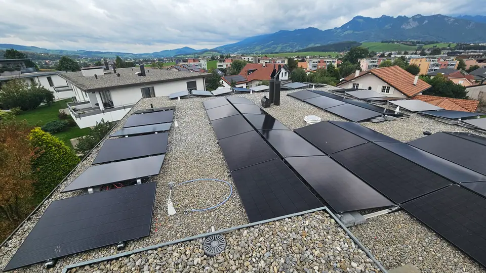 Modules surélevés sur le toit plat gravillonné à Bulle, Préalpes gruériennes en arrière-plan