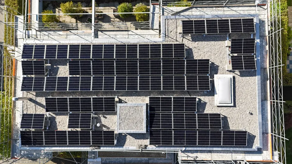 Vue aérienne : modules solaires noirs sur le toit plat d’un immeuble en PPE à Turgi