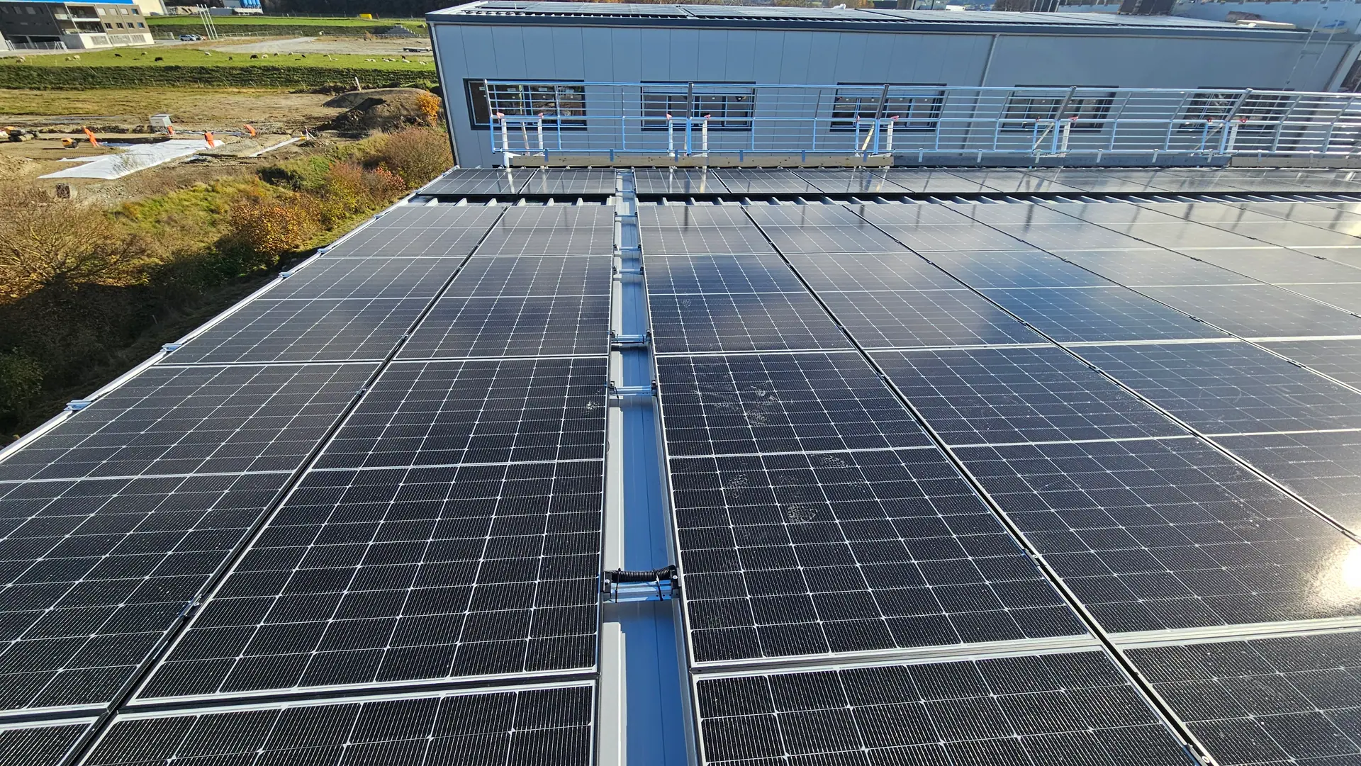 Grosse Photovoltaikanlage von Dimension Solaire auf dem Blechdach einer Gewerbehalle in Rossens